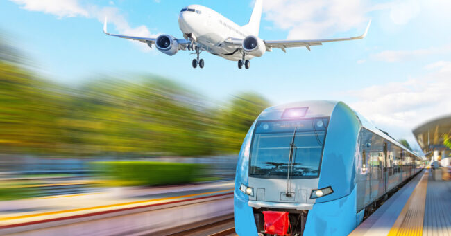 Passenger suburban train at the airport station and landing plane in the sky.